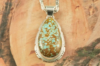 Genuine Number 8 Mine Turquoise Stone set in Sterling Silver Pendant. Free 18" Sterling Silver Chain with Purchase of Pendant. Created by Navajo Artist Larson Lee. Signed by the artist. The Number 8 mine is located in Eureka County Nevada. Since 1976 there has been no Number 8 Turquoise mined. There is however, an existing stock pile that Mr. Dowell Ward, the last owner of the Number 8 mine, had stocked away for later sorting. The Turquoise is a collector's item--because once the reserve is gone there will be no more material released onto the market. The Gold Mining Company owns the claim to the Number 8 mine and it has been swallowed up by the gold mining operations. This is some of the last Number 8 Turquoise to be had and will be a great addition to your collection.